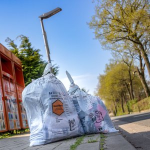 Die Kolpingsfamilie Hollage sammelt Altkleider per Straßensammlung sowie ganzjährig per Container. Altkleidersäcke am Straßenrand vor den Sammelcontainern der Kolpingsfamilie Hollage.