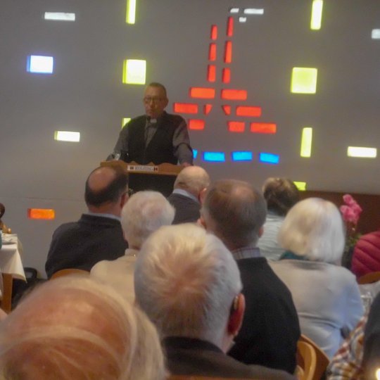 Vor 70 Gästen spricht Diakon Joachim Meyer beim 60plus-Frühstück über die Osnabrücker Wärmestube.