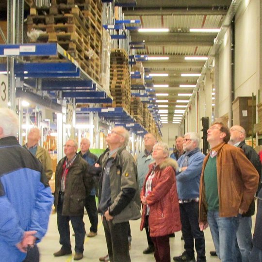 Björn Schütte (links) präsentiert den Gästen der Kolpingsfamilie Hollage die 13.000 Quadratmeter große Lagerhalle.