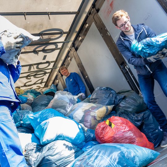 Fleißige Helfer beim Verladen der gesammelten Altkleider in den Transport-Lkw.