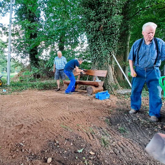 Manfred Haustermann, Peter Glose und Johannes Holtmeyer (von links) stellen die Bank am Schleusenweg auf.