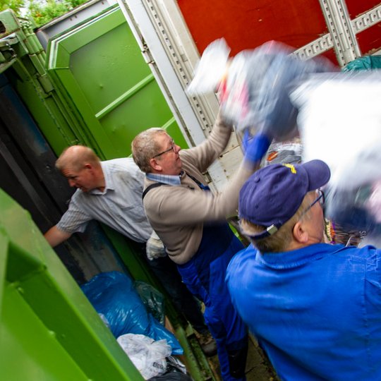 Aktive der Kolpingsfamilie Hollage verladen die gesammelten Altkleider in einen Lkw.