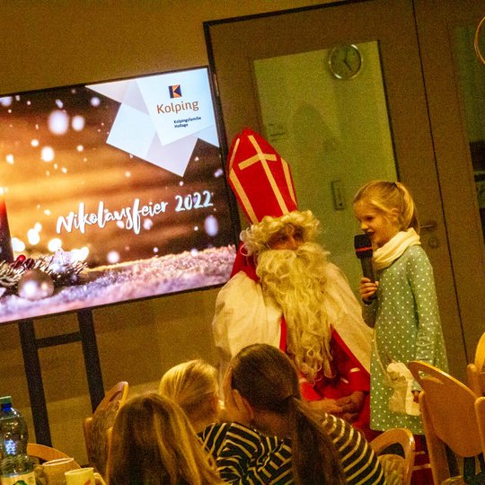 St. Nikolaus hört aufmerksam zu, was die Kinder ihm vortragen.