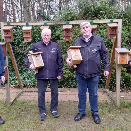 Eric Weber und Johannes Holtmeyer mit ihren „Kolpinghäusern“, sowie Helmut Kühl und Josef Thöle (von links), die beim Aufhängen der Kästen behilflich sind.