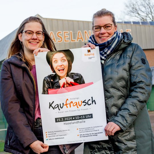 Janina Bode und Martina Unland mit dem Plakat zu „Kolpings Kaufrausch“ vor der Haselandhall.