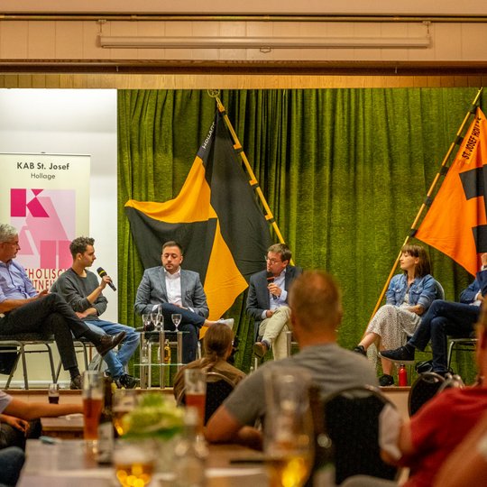 Auf der Bühne im Saal Barlag: Dr. Mathias Middelberg (CDU), Nemir Ali (FDP), Manuel Gava (SPD), Moderator Ulrich Waschki, Heidi Reichinnek (Die Linke) und Thomas Klein (Bündnis 90/Die Grünen).