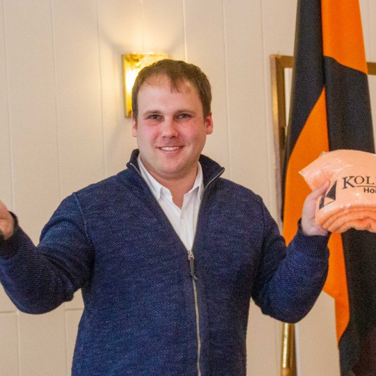 Die Kolpingsfamilie Hollage dankt Kristian Pohlmann mit einer Flasche Wein und einem Kolping-Handtuch.