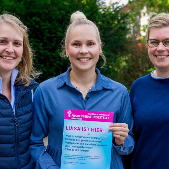 Franziska Matt, Julia Marx und Martina Unland mit einem Hinweis-Plakat auf das „Luisa ist hier!“-Konzept, das beim Hollager Oktoberfest zum Einsatz kommt.