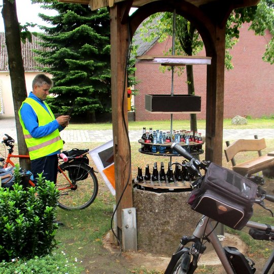 Hier macht man gerne Pause: Dorfplatz in Bieste mit einem Brunnen voll mit kühlen Getränken.