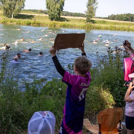Vom Ufer aus feuern die Fans die Schwimmerinnen und Schwimmer an.