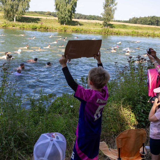 Vom Ufer aus feuern die Fans die Schwimmerinnen und Schwimmer an.